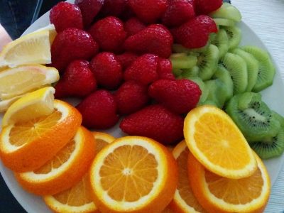 fruits トルコ 猫歩き 色鮮やかで綺麗なフルーツの写真。オレンジ いちご、キウィフルーツが白い皿に盛られている美しい写真 画像